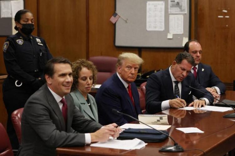 Former U.S. President Donald Trump appears in court with members of his legal team for an arraignment on charges stemming from his indictment by a Manhattan grand jury following a probe into hush money paid to porn star Stormy Daniels, in New York City, U.S., April 4, 2023. REUTERS/Andrew Kelly/Pool