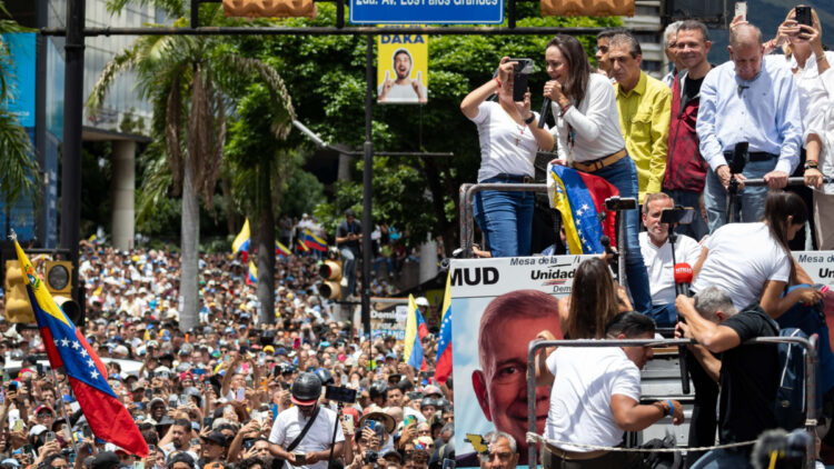 AME6591. CARACAS (VENEZUELA), 30/07/2024.- La líder opositora venezolana María Corina Machado (i) habla junto al candidato a la presidencia de Venezuela Edmundo González Urrutia (d) este martes, en Caracas (Venezuela). Miles de venezolanos se han concentrado este martes en Caracas, en un acto convocado por la oposición mayoritaria, para rechazar por segundo día consecutivo lo que consideran es un fraude en los resultados oficiales del Consejo Nacional Electoral (CNE), que en la víspera proclamó a Nicolás Maduro como presidente reelecto con el 51,2 % de los votos. EFE/ Ronald Peña R.